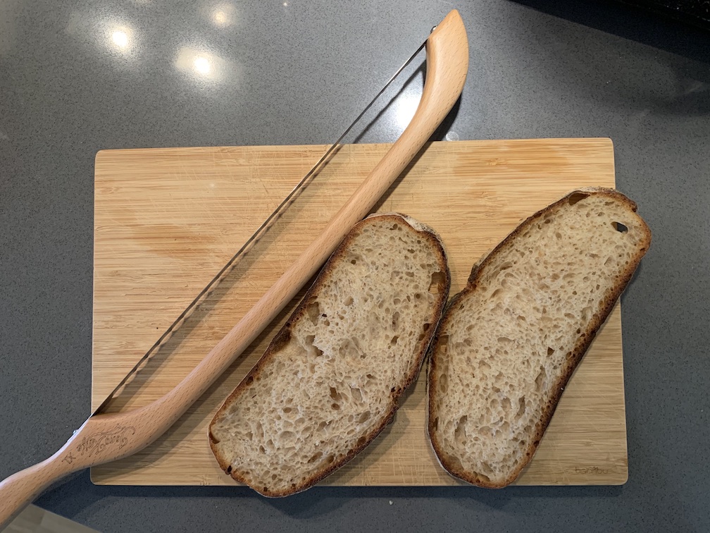 A weird bread knife with some slices of bread