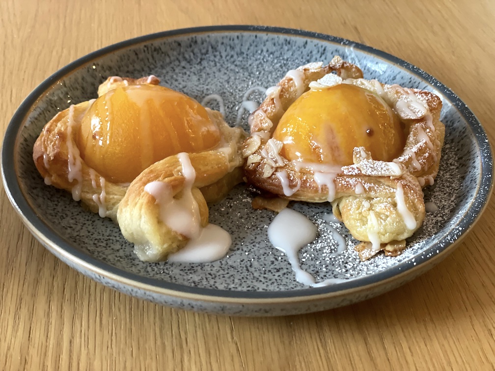 Two messy-looking peach Danish pastries
